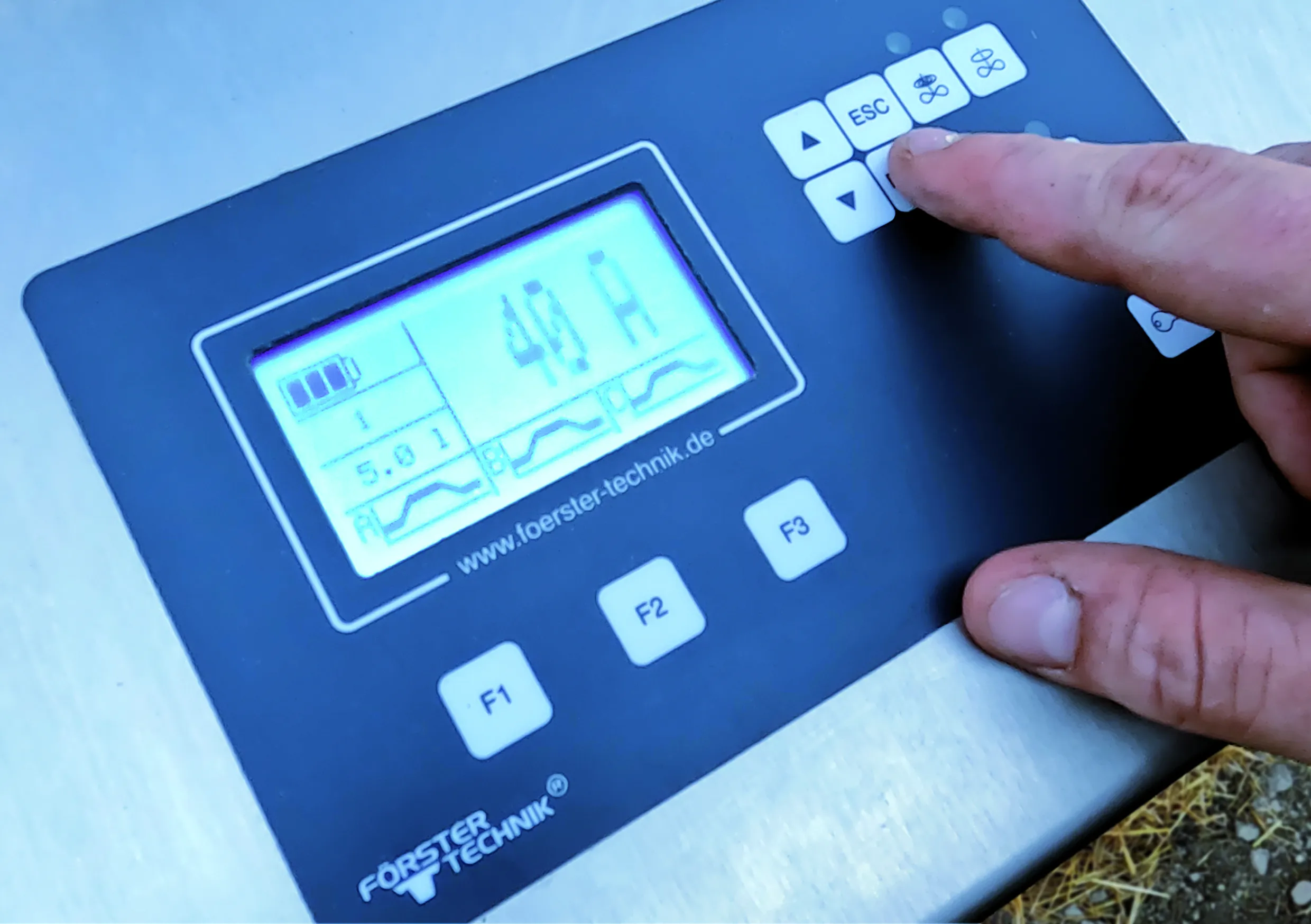 L'agriculteur règle le CalfPlan via l'écran pour garantir une alimentation précise et adaptée à l'âge de ses veaux, favorisant ainsi leur développement optimal.